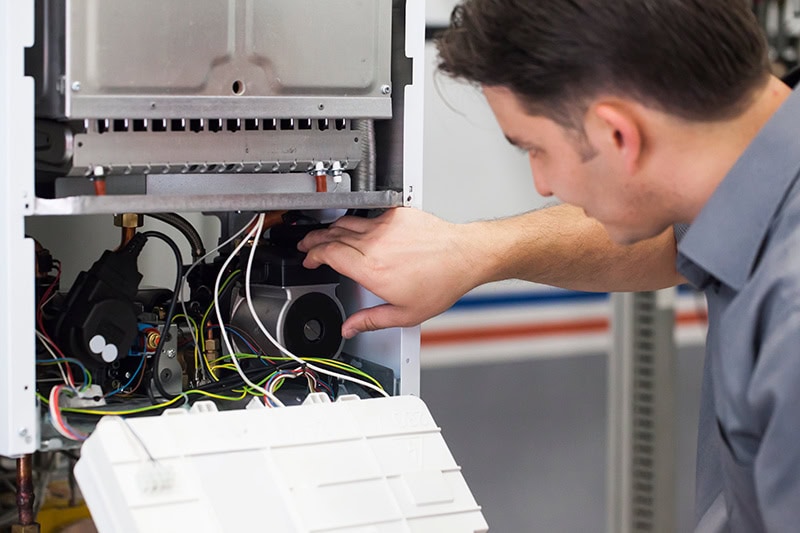 Technician performing maintenance on a heat pump.